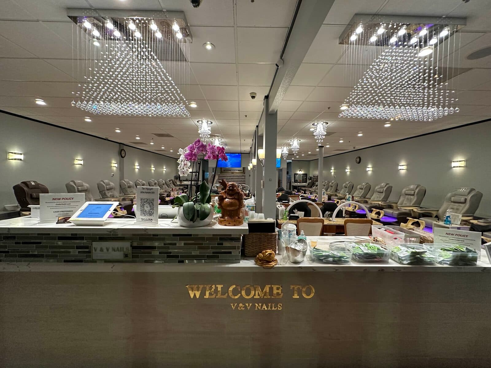 Quầy V & V Nail Spa nhìn vào ghế tiệm, với biển WELCOME TO V & V NAILS.